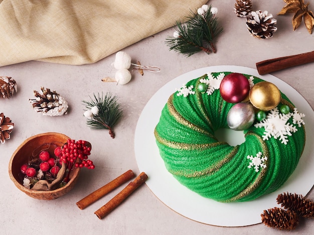 Foto composición de pastel de navidad verde con conos y canela