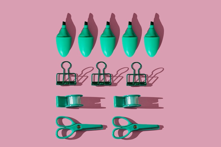 Foto composición de patrón plano laico con suministros de papelería verde escolar sobre fondo rosa pastel color vivo mínimo tiro cenital concepto de regreso a la escuela vista superior con sombras nítidas