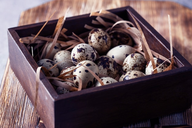 Composición con pequeños huevos de codorniz en el fondo de madera natural