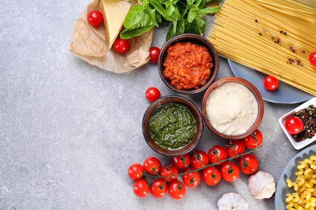 Composición con pesto boloñesa y salsas blancas para pasta en tazones en la mesa