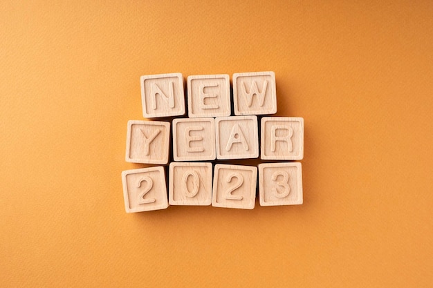 Una composición plana de Año Nuevo hecha de cubos de madera con el texto Año Nuevo 2023 Concepto de Navidad Tarjeta de felicitación para vacaciones de invierno Diseño plano