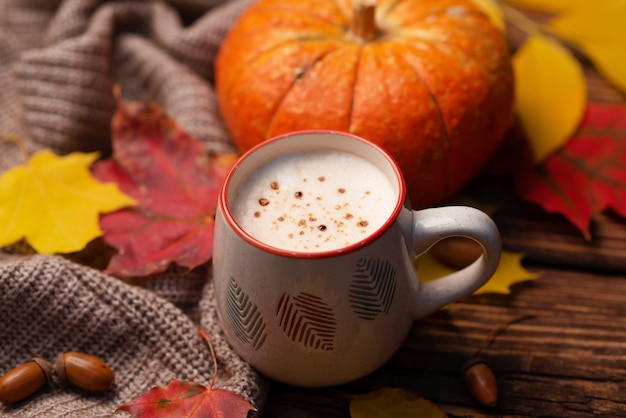 Composición plana con calabaza y taza de bebida caliente