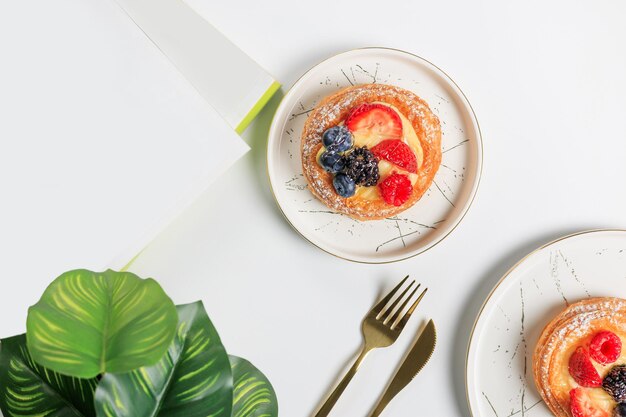 Composición plana con deliciosas tortillas de bayas sobre un fondo blanco