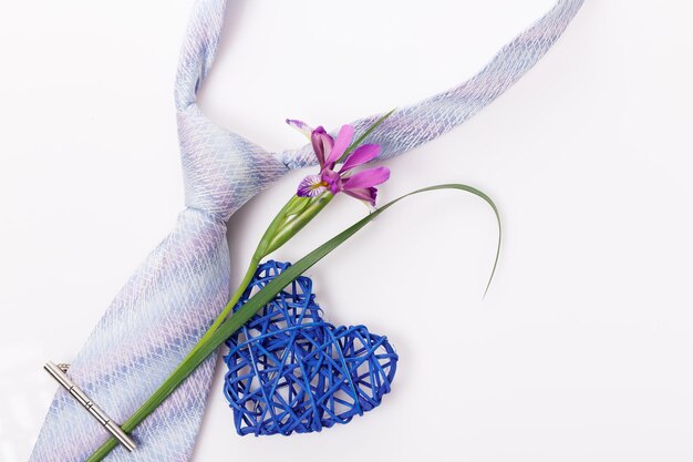 Composición plana laico con accesorios de hombre flor y corazón sobre fondo blanco.