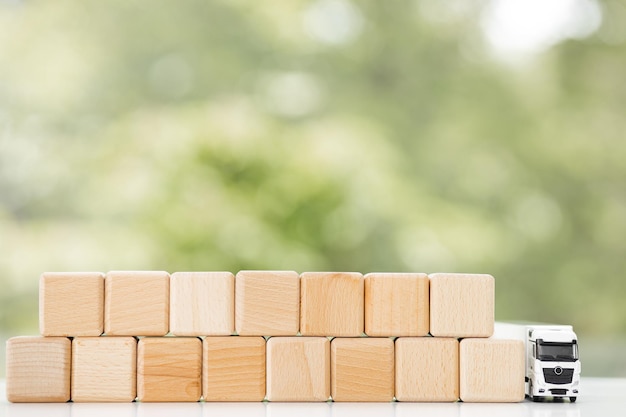 Composición plana laico de camión de juguete con cubos de madera sobre fondo verde Concepto de logística