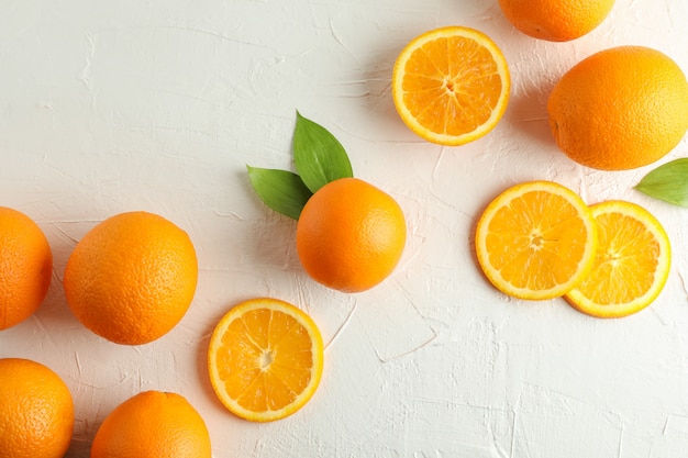 Composición plana laico con naranjas maduras sobre fondo blanco. Vista superior