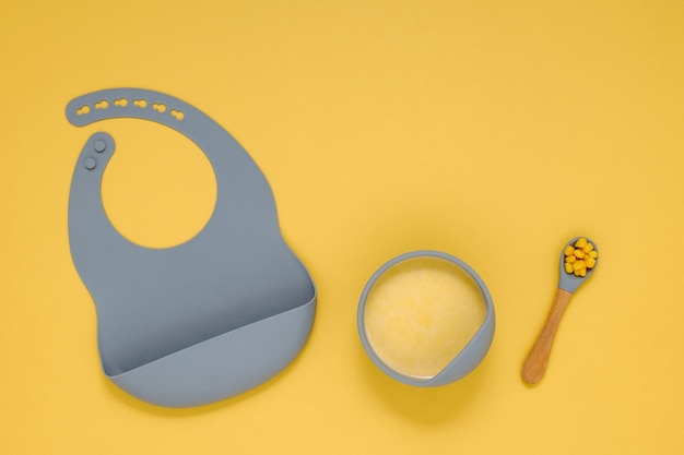 Composición plana laicos de alimentos saludables para bebés sobre fondo amarillo Cuidado del bebé y primer señuelo