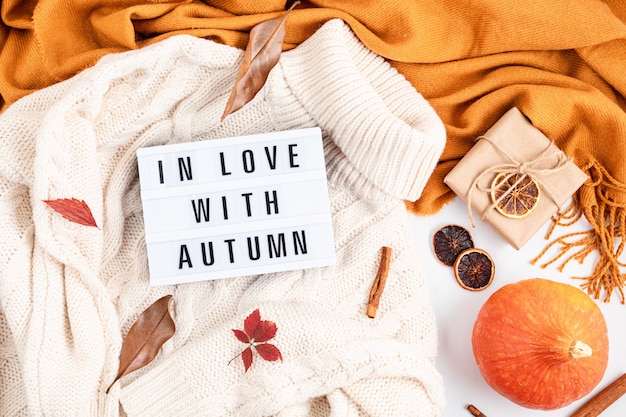 Composición plana de otoño con caja de luz con la frase Enamorado del otoño