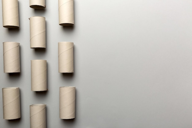 Composición plana con rollos de papel higiénico vacíos y espacio para texto sobre fondo de color Tubo de papel reciclable con extremo de tapón metálico hecho de papel kraft o cartón