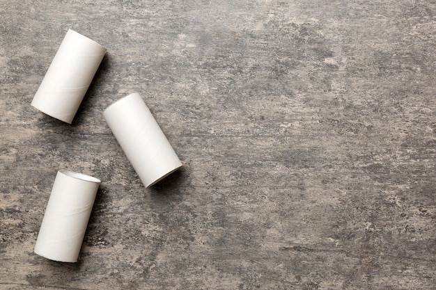 Composición plana con rollos de papel higiénico vacíos y espacio para texto sobre fondo de color Tubo de papel reciclable con extremo de tapón metálico hecho de papel kraft o cartón