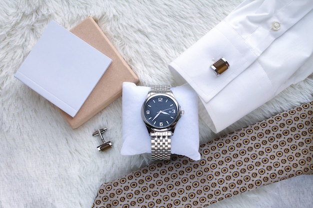 Composición plana con vista superior de reloj de pulsera, corbata, camisa y gemelos de lujo para hombres