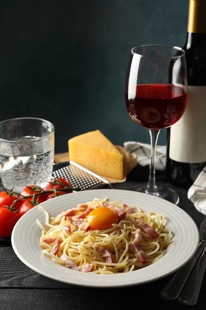 Composición con plato de sabrosa pasta y vino en madera