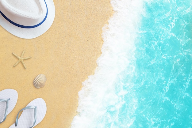 Composición de playa de vista superior con zapatillas de sombrero, estrella y concha en la arena con olas de mar al lado