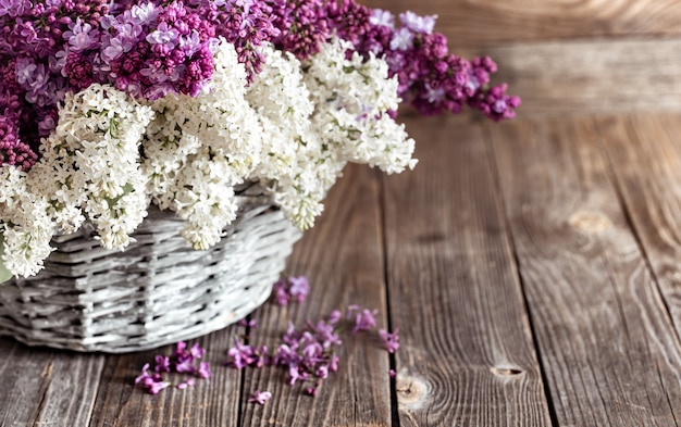 Composición de primavera con flores lilas en una canasta de mimbre. concepto de cestas y entregas de flores.