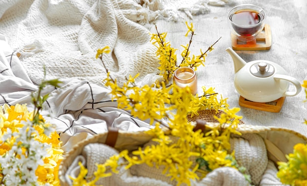 Composición de primavera con una taza de té y flores. Mesa de luz acogedora y ambiente hogareño.