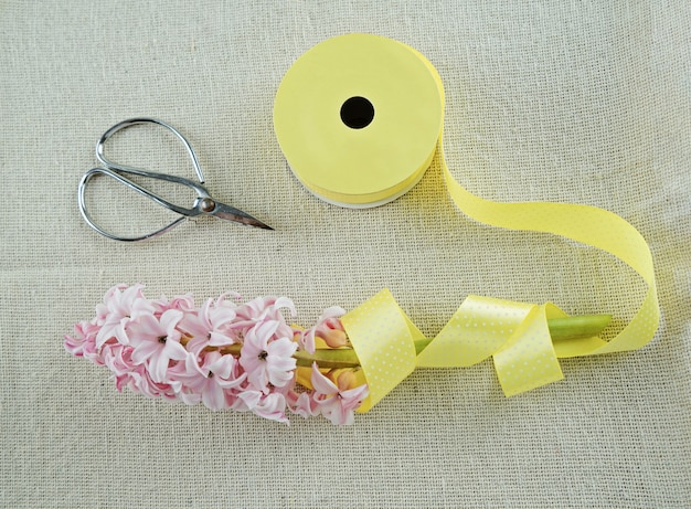 Composición primaveral de cinta, tijeras y jacinto.