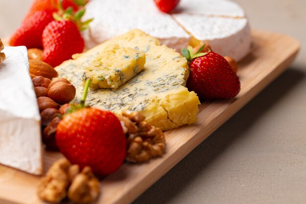 Composición de queso y frutas en mesa gris