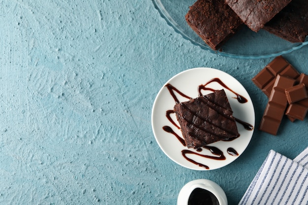 Composición con rebanadas de pastel de chocolate en azul, espacio para texto