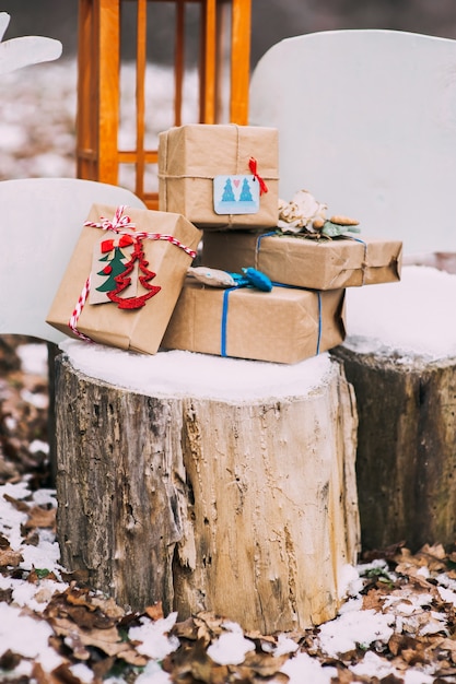 composición con regalos de Navidad en el bosque, en el tocón, nieve