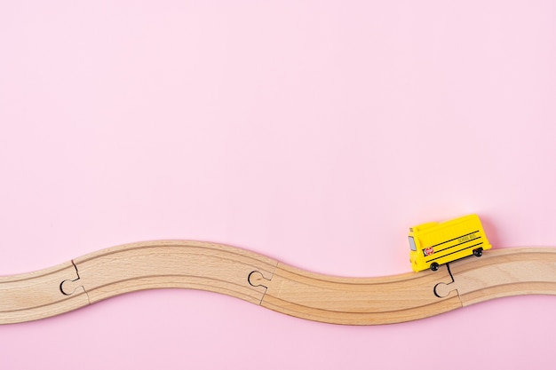 Foto composición de regreso a la escuela con modelo de autobús escolar amarillo y camino de madera