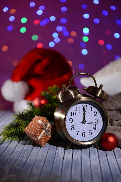 Foto composición con reloj despertador retro y decoración navideña sobre fondo brillante