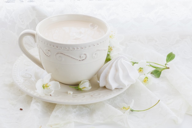 Composición romántica con taza de té, zephyr y flores de manzana