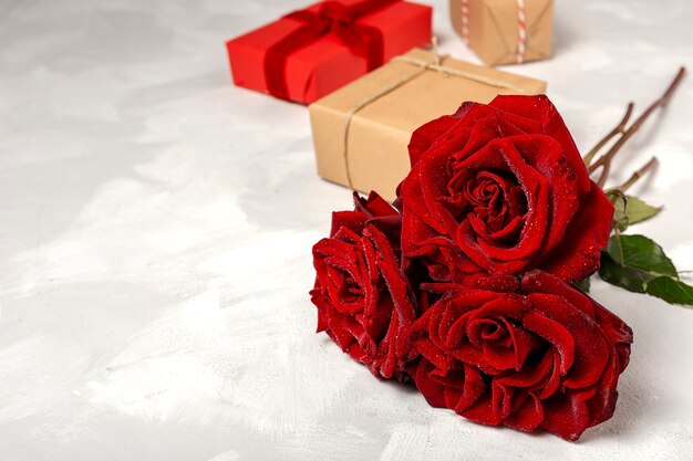 Composición de rosas rojas y cajas de regalo.