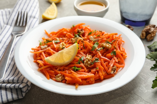 Composición con sabrosa ensalada de zanahoria sobre fondo gris