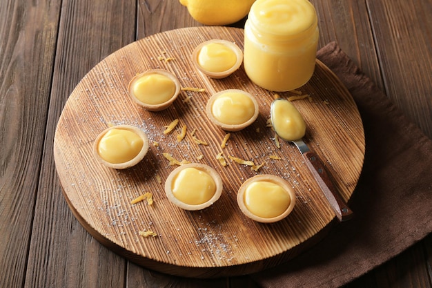 Composición con sabrosas galletas y cuajada de limón sobre mesa de madera