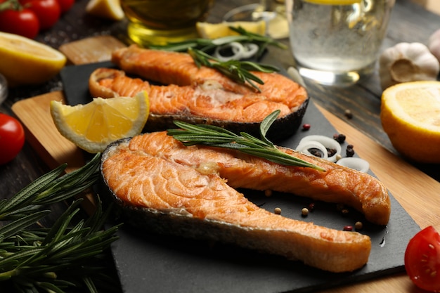 Composición con sabroso salmón a la parrilla sobre fondo de madera, de cerca