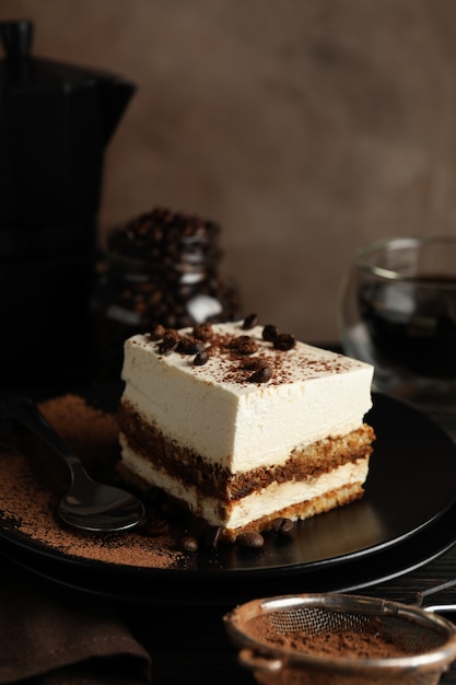 Composición con sabroso tiramisú y café sobre fondo de madera