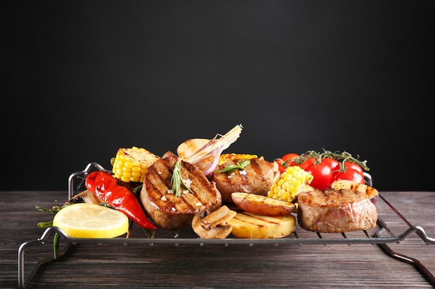 Composición con sabrosos bistecs a la parrilla y verduras en la mesa