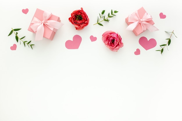 Composición de San Valentín: cajas de regalo rosa con cinta, corazón y rosa