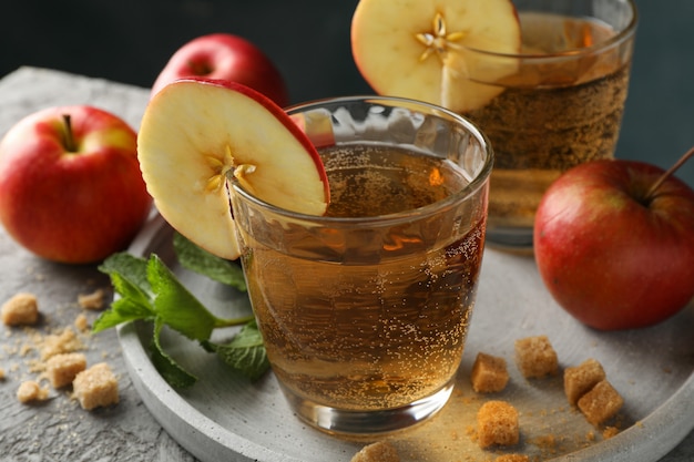 Composición con sidra, azúcar y manzanas en mesa gris