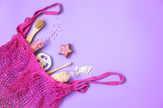 Composición de spa con accesorios de baño en una bolsa de hilo rosa plana