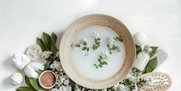 Composición de spa con agua para tratamientos de belleza y flores frescas.