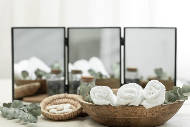 Foto composición de spa con toallas en un plato de madera sobre un fondo borroso