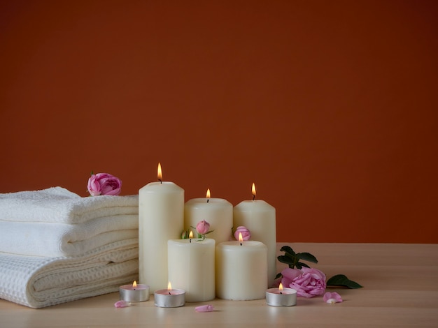 Composición de spa con velas aromáticas y rosas en la mesa de madera