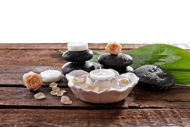 Composición de spa de velas de piedras y una rosa aislada en blanco