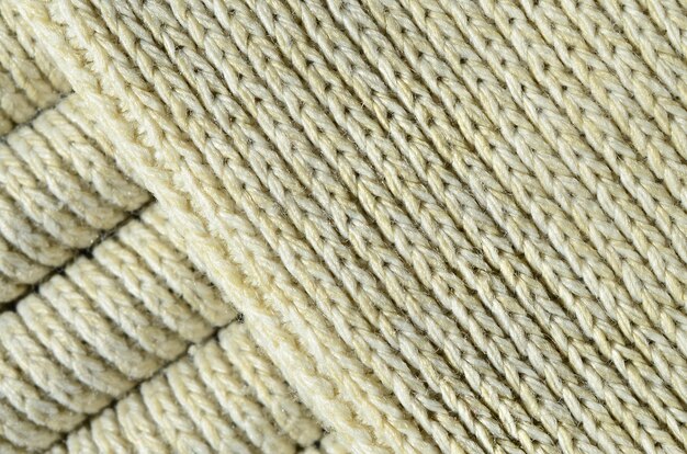 Foto composición de un suéter de punto amarillo suave. textura macro de ligaduras en hilos.