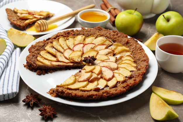 Composición con tarta de manzana e ingredientes sobre fondo gris. Comida hecha en casa
