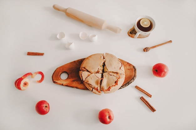 Composición con una tarta de manzana recién horneada con ingredientes