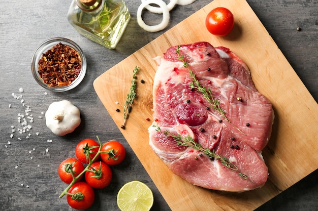 Composición con tomillo de bistec crudo fresco y verduras en la mesa