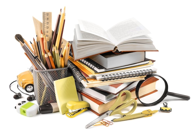 Composición de útiles escolares con libro abierto y lupa aislado sobre fondo blanco