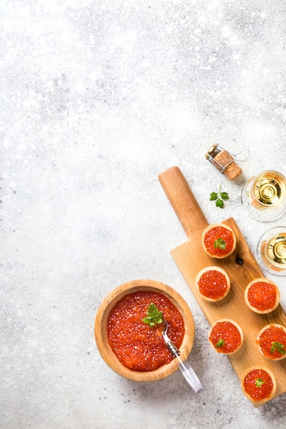 composición de vacaciones Caviar de salmón rojo en un tazón de madera