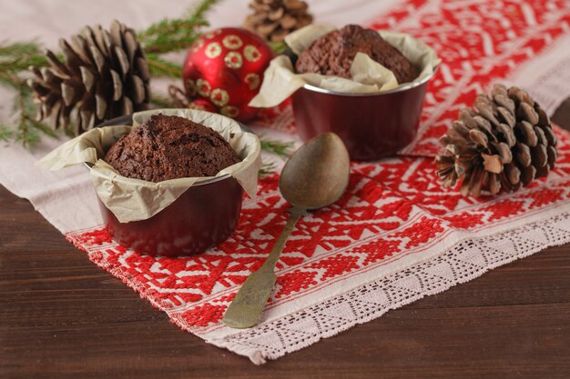 Composición de vacaciones de invierno de Navidad y Año Nuevo de dos pasteles en la mesa de madera nevada con ramas de abeto verde