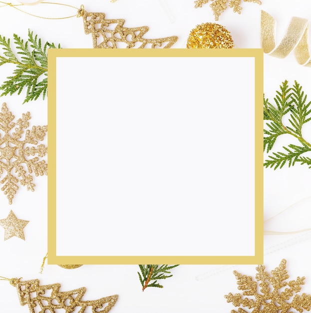 Composición de vacaciones de Navidad. Patrón de oro creativo festivo, bola de vacaciones de decoración de oro de Navidad con cinta, regalo, copos de nieve, árbol de Navidad sobre fondo blanco. Endecha plana, vista superior