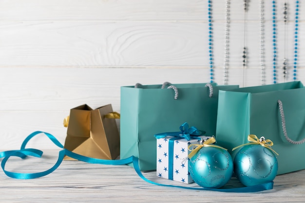 Composición de venta de compras navideñas con bolsas de papel azul y decoraciones