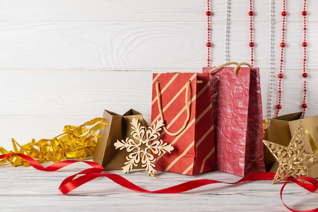 Composición de venta de compras navideñas con bolsas de papel rojo y decoraciones