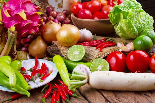 Composición con verduras orgánicas crudas surtidos en la mesa de madera vieja